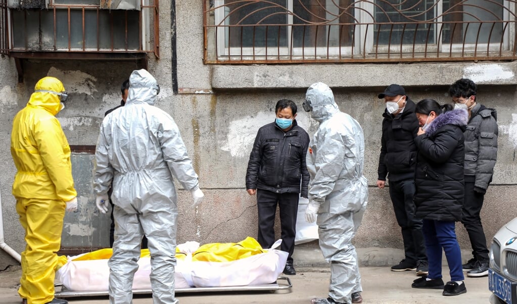 Begin februari 2020 halen uitvaartverzorgers in Wuhan het lichaam op van een man die vermoedelijk aan corona is overleden. (beeld epa / Yuan Zheng)