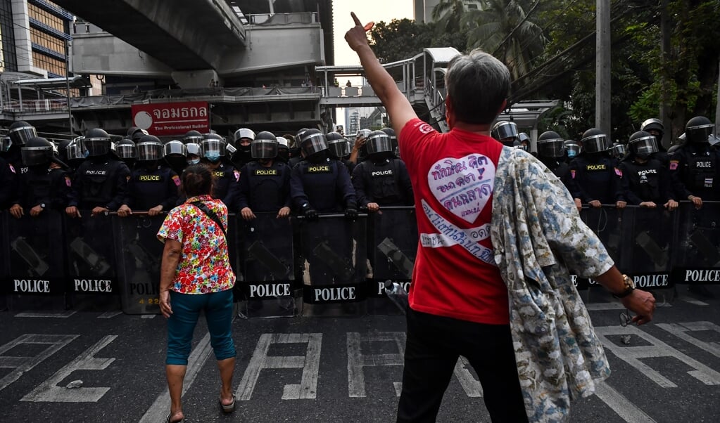 Demonstranten die in Myanmar de straat op gaan voor meer democratie stuiten op een muur aan politieagenten. (beeld afp / Lillian Suwanrumpha)