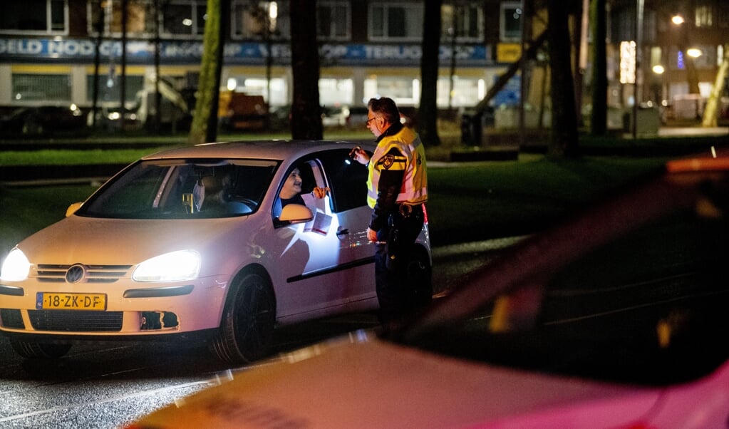 De politie controleert automobilisten op het Zuidplein in Rotterdam-Zuid. Vooral jongeren en jongvolwassenen hebben moeite met de avondklok. (beeld anp)
