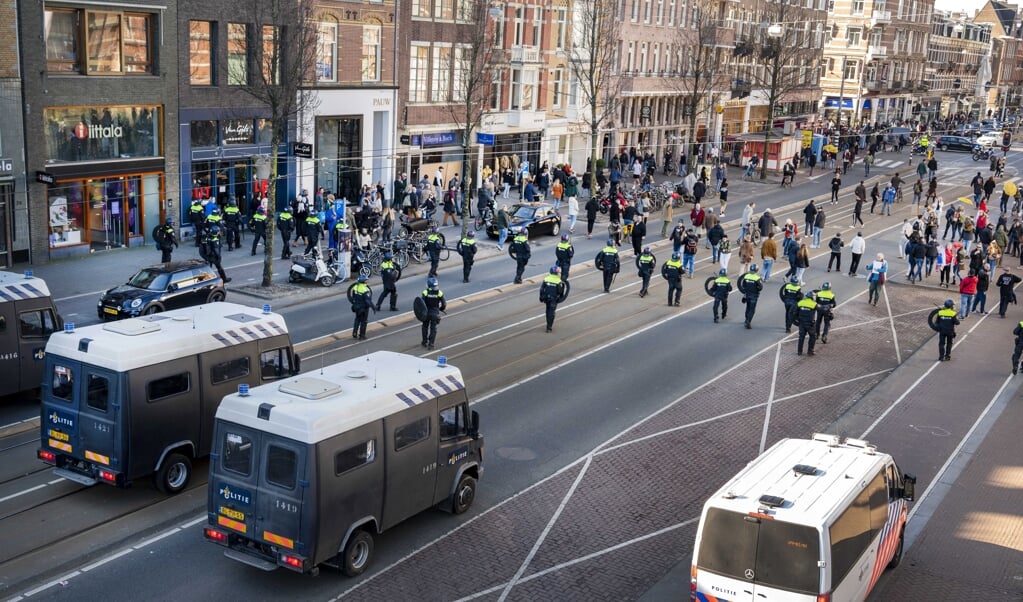 Op last van de Amsterdamse driehoek (burgemeester, politie, justitie) werd zondagmiddag het Museumplein leeggeveegd toen demonstranten weigerden het plein te verlaten. Ze protesteerden tegen de huidige coronamaatregelen. (beeld epa / Evert Elzinga)