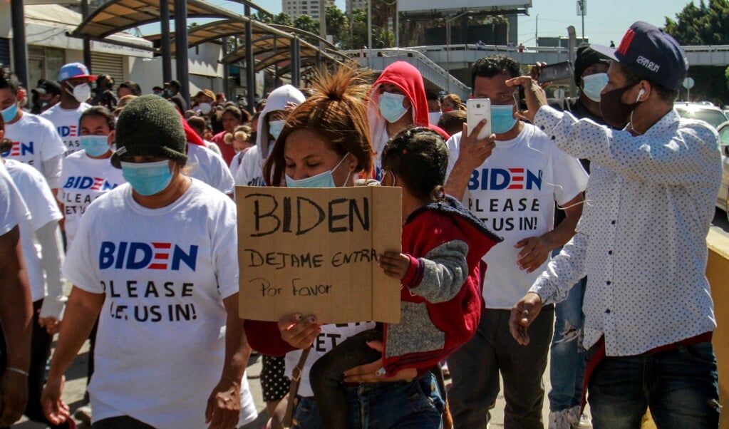 Een groep migranten in Tijuana, Mexico, doet een beroep op president Biden om hen toe te staan de Verenigde Staten in te mogen. (beeld epa / Joebeth Terriquez)