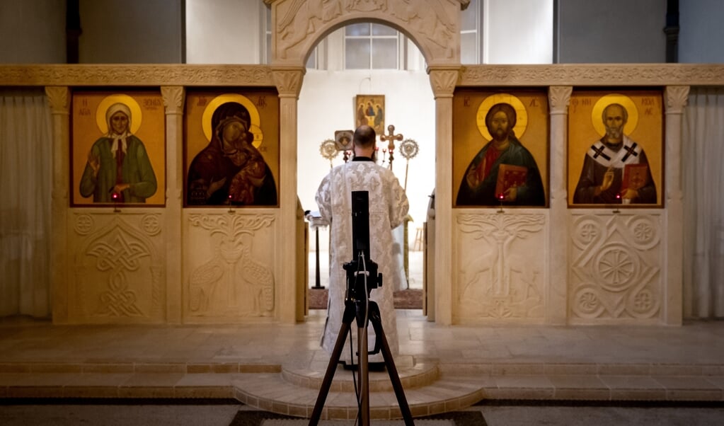 Een online viering in de Russisch Orthodoxe kerk in Amsterdam, gestreamed voor gelovigen thuis en passend bij het huidige niveau 'zeer ernstig'. (beeld anp / Koen van Weel)