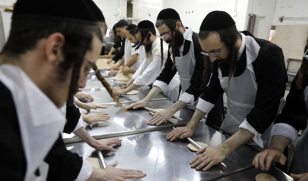 Joden maken in een bakkerij matzes – brood dat niet gerezen is – ter voorbereiding op Pesach, dat aflopen zaterdag begon. (beeld Menahem Kahana)