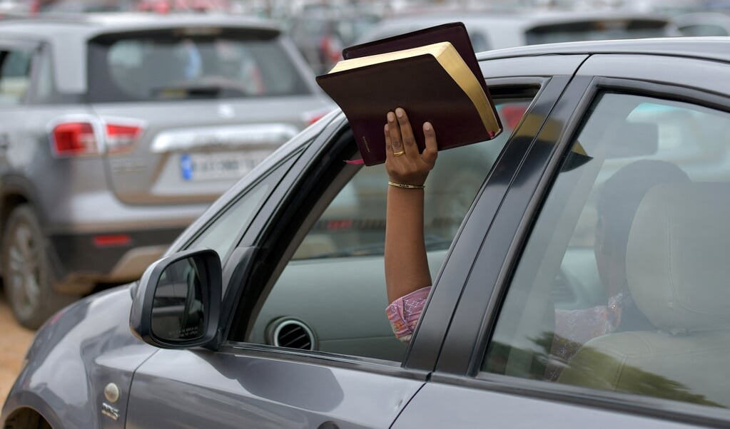 Een vrouw houdt haar Bijbel in de lucht tijdens een openluchtdienst van Bethel Church. Paul Pressler was jeugdleider van de bekende kerk. (beeld Manjunath Kiran / afp)