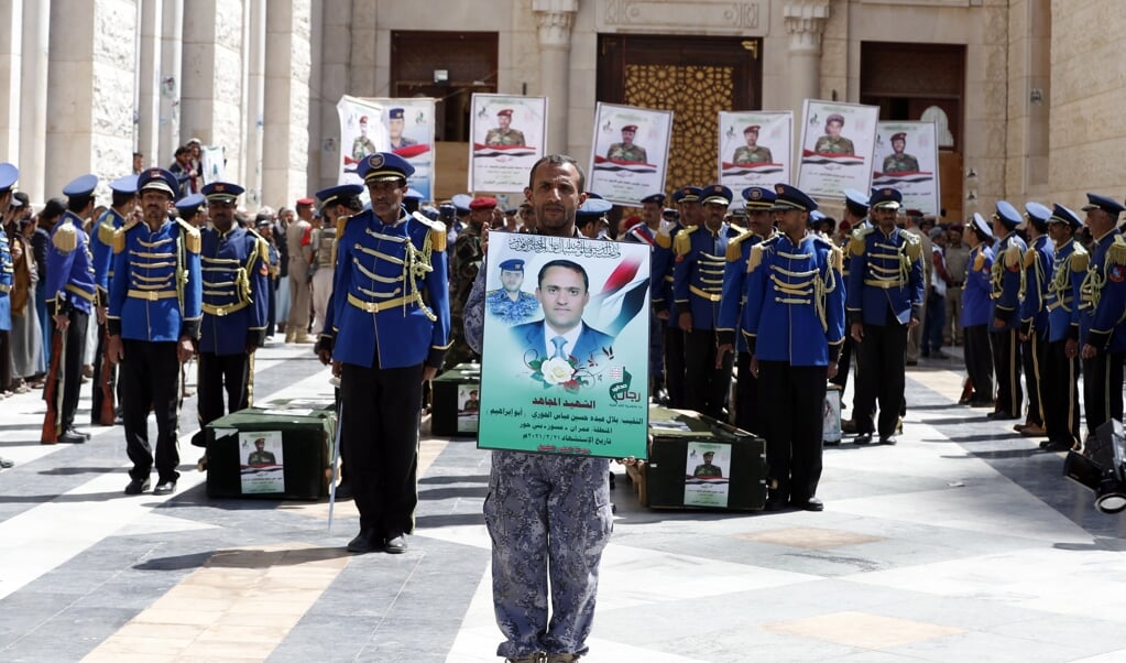 Een pro-Houthi millitant houdt een portret vast van een Houthistrijder die is omgekomen in de opgelaaide gevechten. (beeld epa / Yahya Arhab)