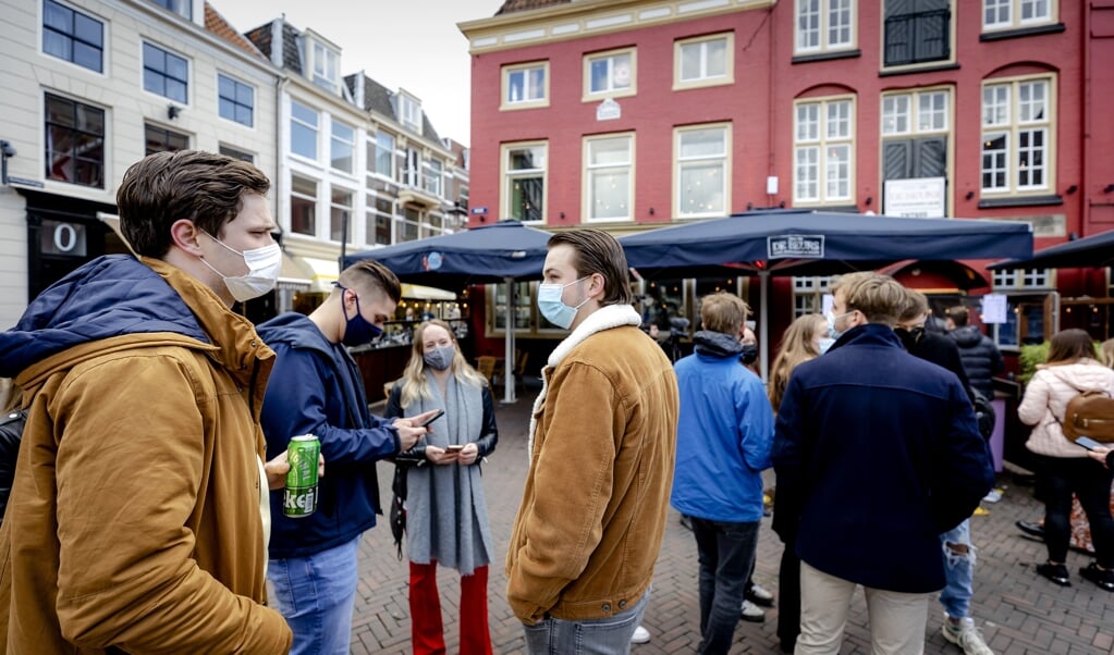 Bezoekers staan in de rij voor café De Beurs. Vijf Utrechtse cafés laten enkele dagen gasten toe, op vertoon van een negatief coronatestbewijs. (beeld anp / Robin van Lonkhuijsen)