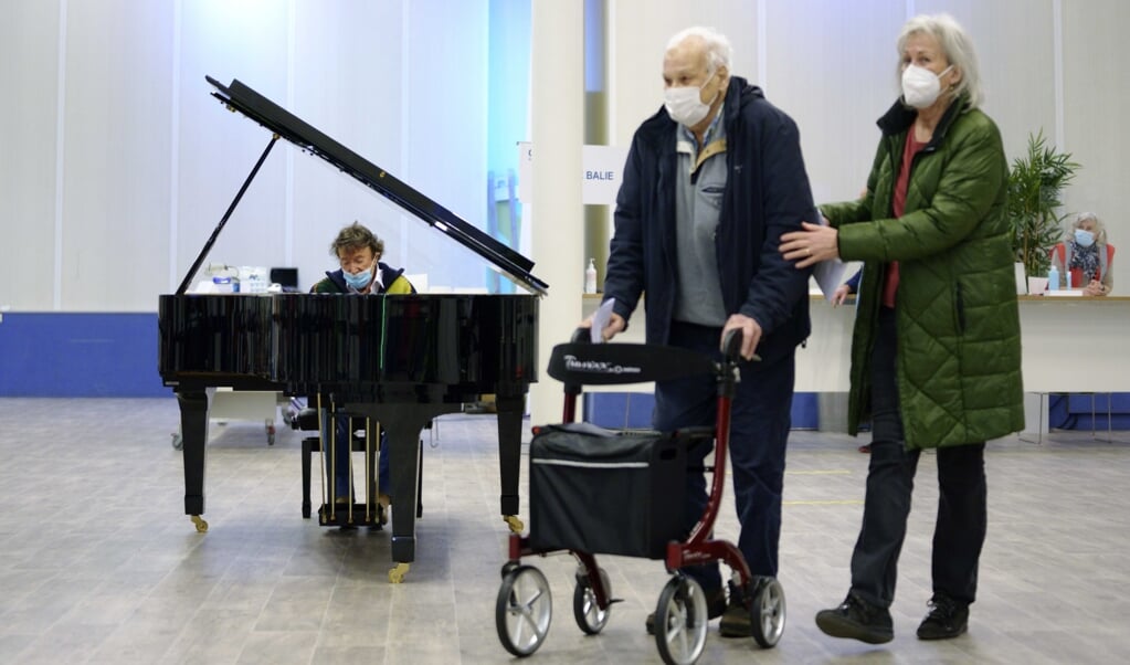 Bezoekers van een vaccinatielocatie in Leiden vielen afgelopen weekend opeens in een pianoconcert van Laurens van Rooyen, bedoeld als steun voor alle GGD- en Rode Kruis-medewerkers die hulp bieden bij het vaccineren. (beeld epa / Phil Nijhuis)