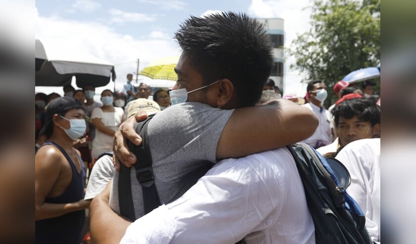 Activist Zayar Lwin begroet een vriend, nadat hij is vrijgelaten uit de gevangenis in Yangon. (beeld epa)