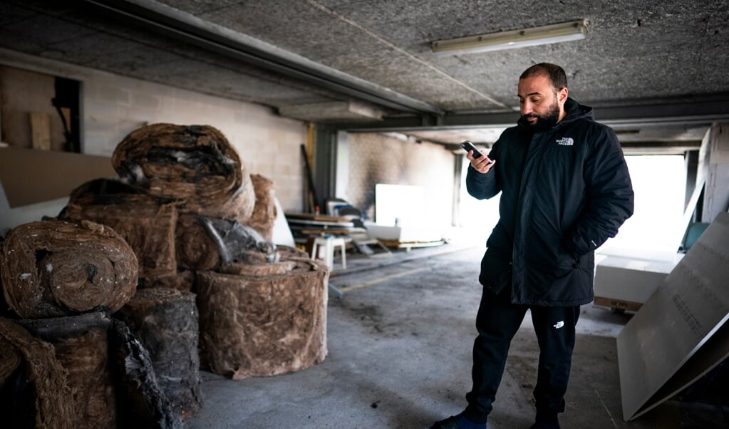 Fouad Khouakhi kijkt op zijn telefoon naar reacties op de brand in de moskee in Gouda. (beeld Freek van den Bergh)