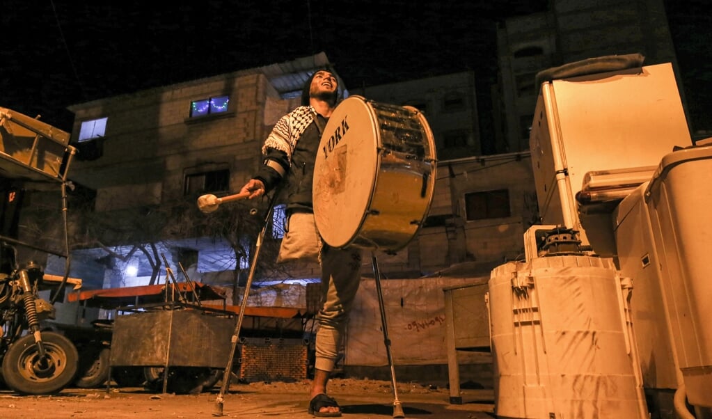 Een ‘ramadan drummer’ gaat door de straten in Rafah om de vastende moslims te wekken voor het ontbijt vóór zonsopgang. (beeld afp / Said Khatib)