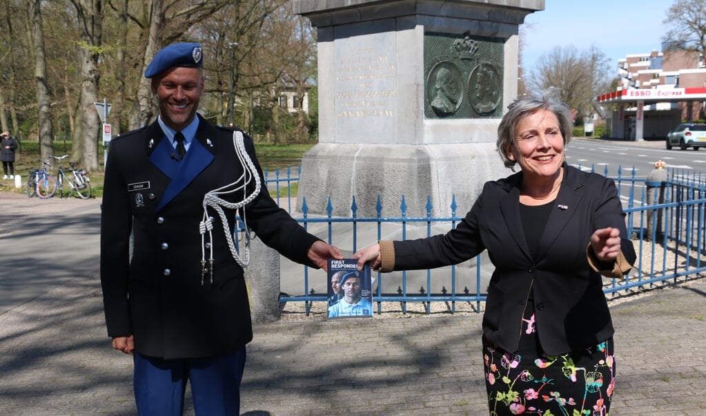Demissionair minister Bijleveld van Defensie kreeg bij De Naald in Apeldoorn het eerste exemplaar van het boek van Renaldo Ishaak. (beeld)