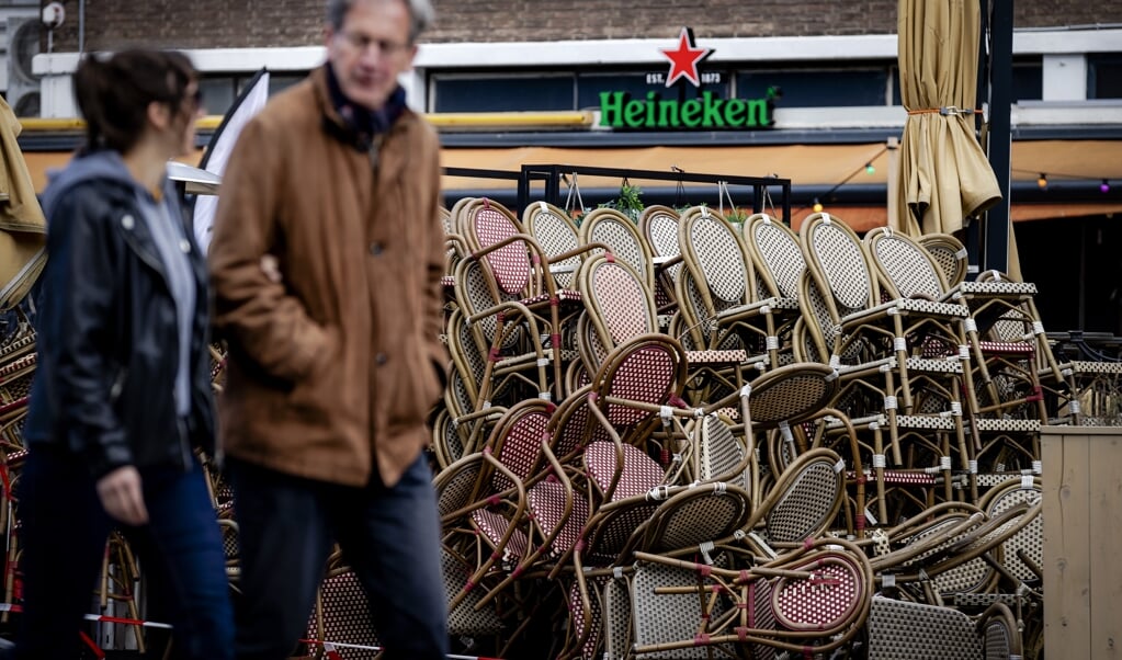 Stoelen en tafels van een terras staan opgestapeld in Rotterdam. (beeld anp / Robin van Lonkhuijsen)
