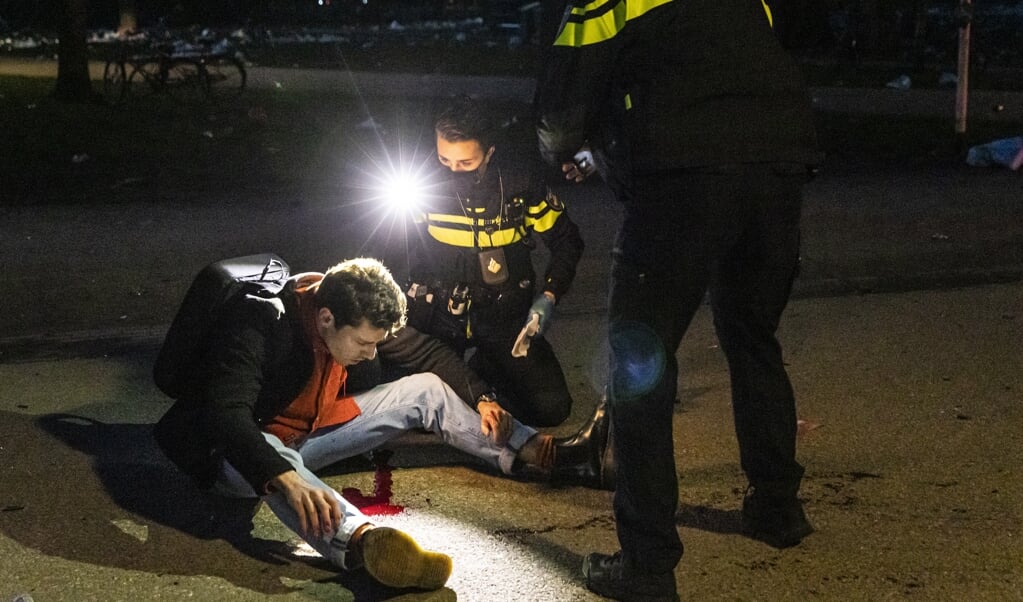 Februari dit jaar: politieagenten helpen een bezoeker die in het Vondelpark op zijn achterhoofd is geraakt door een fles. Echte leiders, 'leiders van hoop', zijn bijvoorbeeld leraren, agenten, verpleegkundigen met oog voor kwetsbaren. (beeld anp / Dingena Mol)