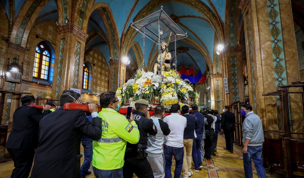 Een Jezusbeeld wordt tijdens een rooms-katholieke processie door een kerk in Riobamba gedragen. (beeld Epa / Jose Jacome)