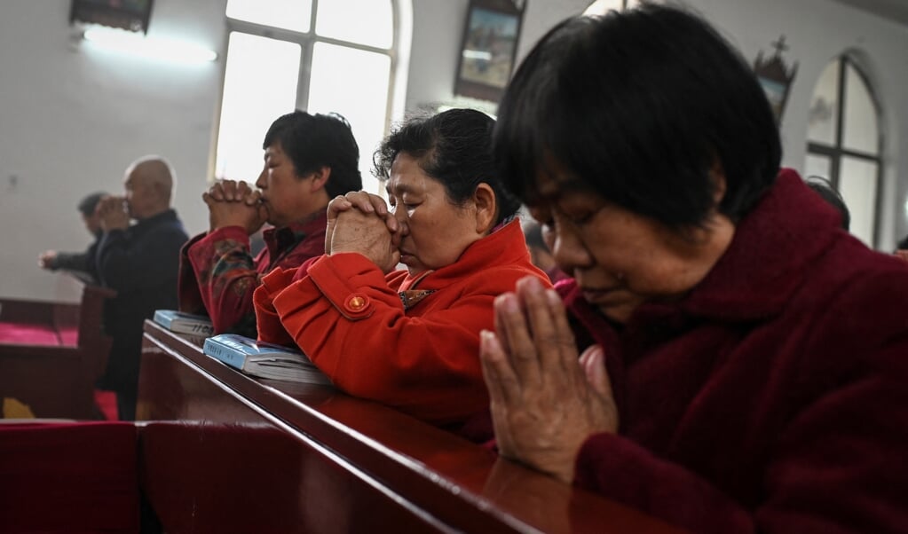 Rooms-katholieke Chinezen bidden in een dorpskerk bij de hoofdstad Peking op Paaszondag. (beeld afp / Jade Gao)