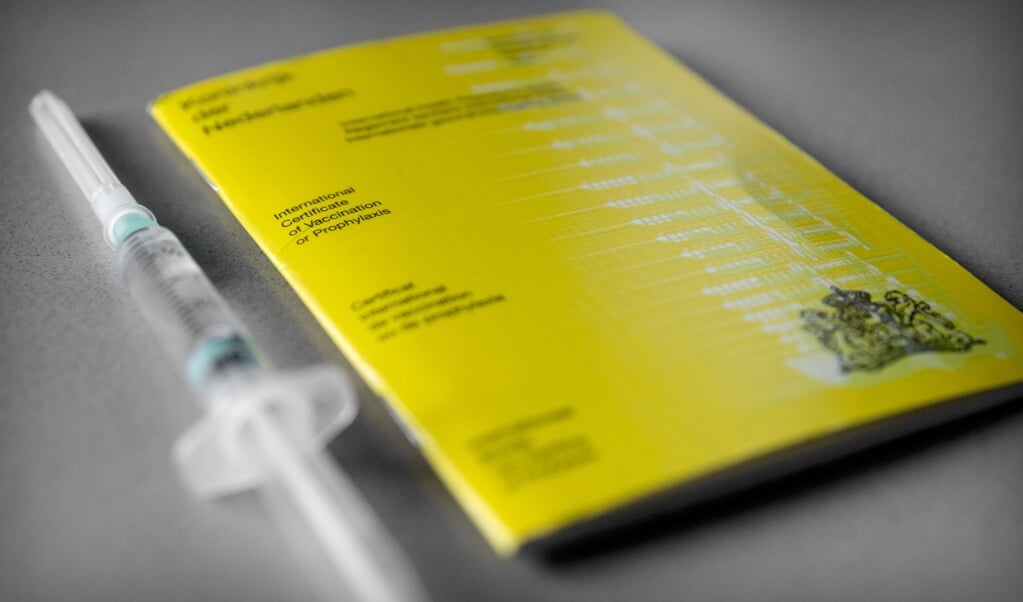 Een geel vaccinatieboekje waarin iemands vaccinaties staan geregistreerd. Het kabinet werkt aan een vaccinatiepaspoort waarmee bezoekers van evenementen straks bij de ingang kunnen laten zien dat dat zij tegen COVID-19 gevaccineerd zijn. (beeld anp / Koen van Weel)