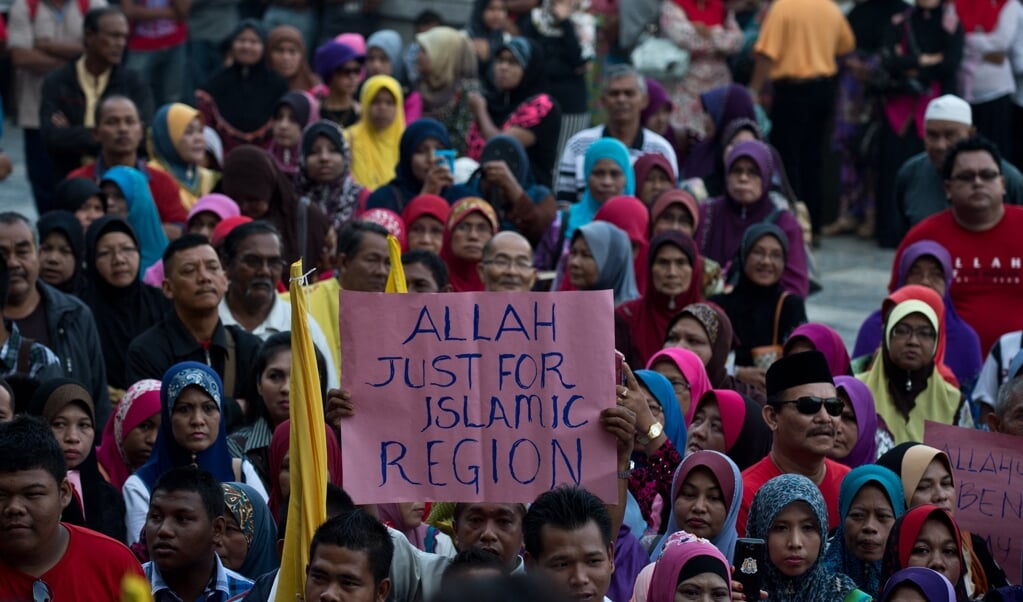 In Maleisië wordt al jarenlang gepraat over de vraag of de roomskatholieke kerk de term 'Allah' voor God mag gebruiken. Beeld: islamitische actievoerders in 2014 voor het Hooggerechtshof in Kuala Lumpur. (beeld afp Photo / Manan Vatsyayana
Manan Vatsyayana / afp)