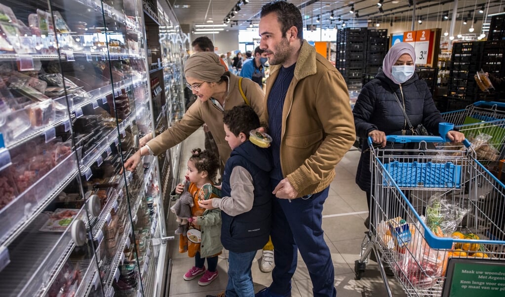 Fatima Llouh en Rachid Lamrabat, het stel achter By Oummi, met hun kinderen bij een AH in België. (beeld Arie Kievit)