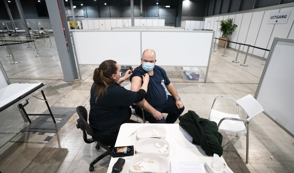Mensen worden in de avonduren in de Jaarbeurs in Utrecht gevaccineerd. Tijdens een pilot gaat de GGD Regio Utrecht op deze locatie tot laat in de avond prikken. (beeld anp / Jeroen Jumelet)