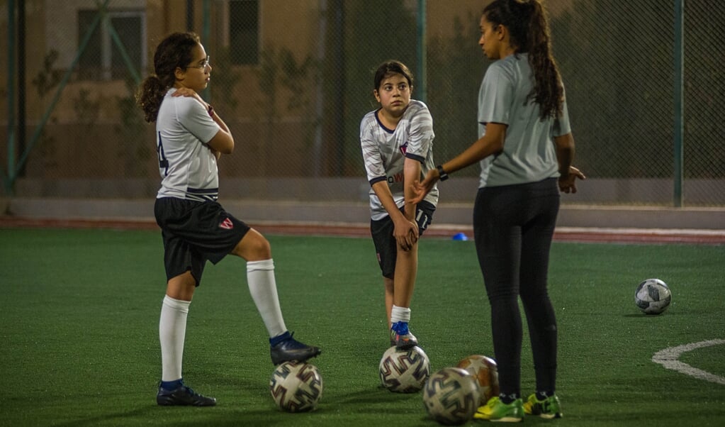 Farida Salem tijdens de training in gesprek met Nour (l) en Sarah. 'Ik geef ze veel adviezen, ze kijken tegen me op.' (beeld René Clement)