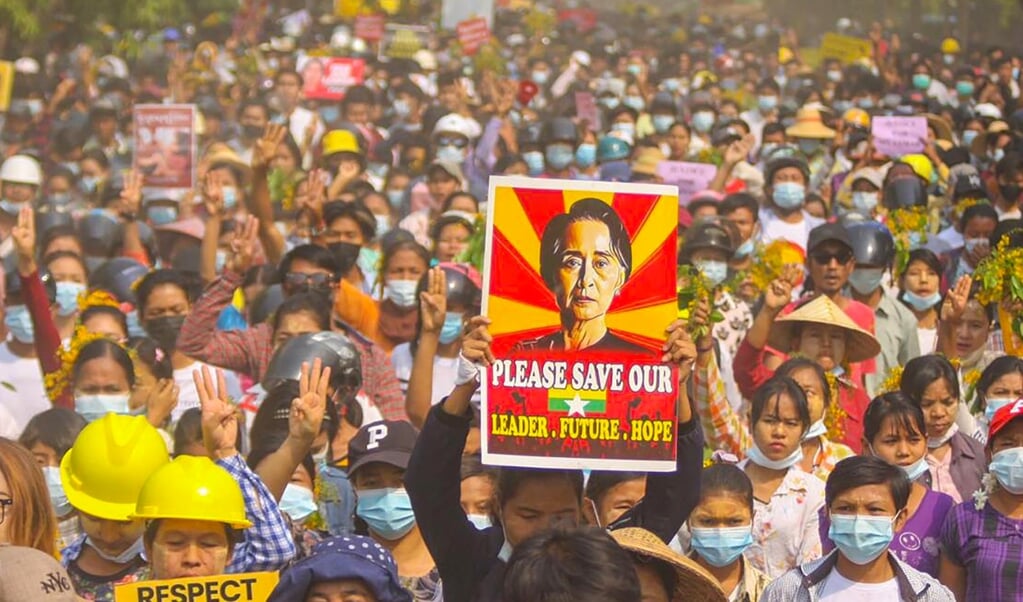 Een demonstrant houdt tijdens een protest tegen de militaire coup in Myanmar een poster met daarop een foto van Aung San Suu Kyi omhoog. (beeld afp)