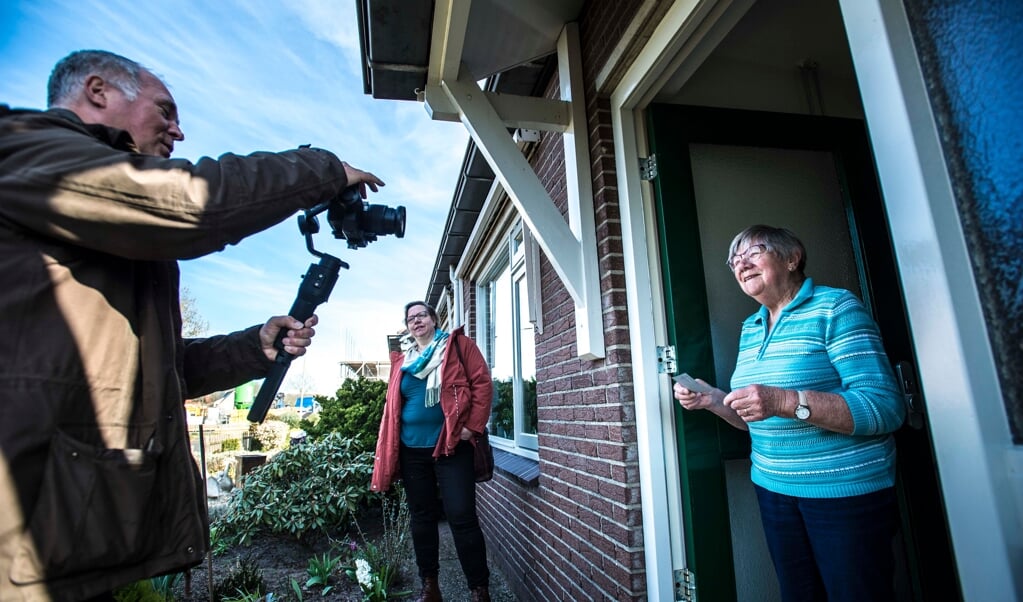 Filmpjes maken voor de onlinedienst; zo probeert voorganger Jolanda Aantjes (midden) de onderlinge betrokkenheid vast te houden. (beeld Carel Schutte)