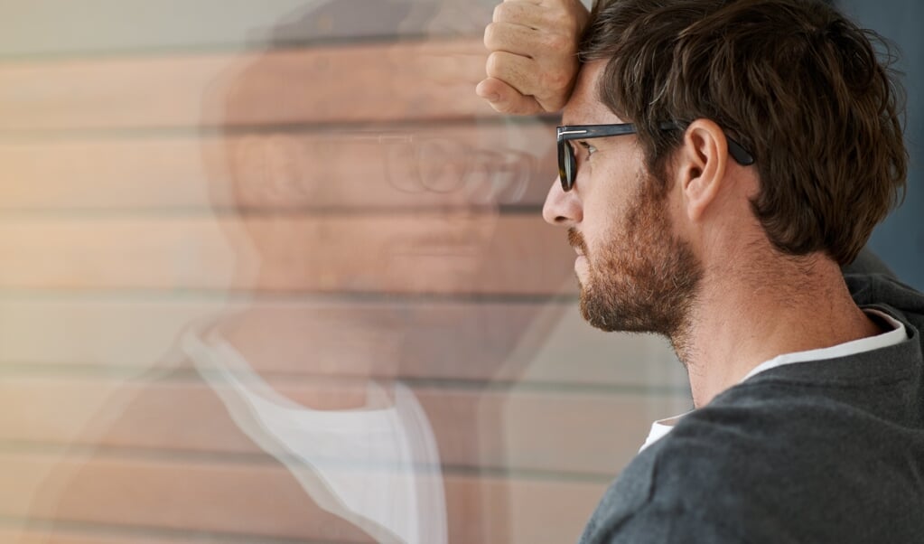 Shot of a thoughtful young entrepreneur leaning against a glass window in his office (beeld JEFF BERGEN )