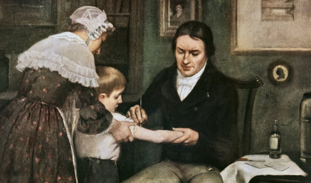 Een schilderij uit de negentiende eeuw laat Jenner zien die een kind vaccineert. (beeld wikipedia / welcome library)