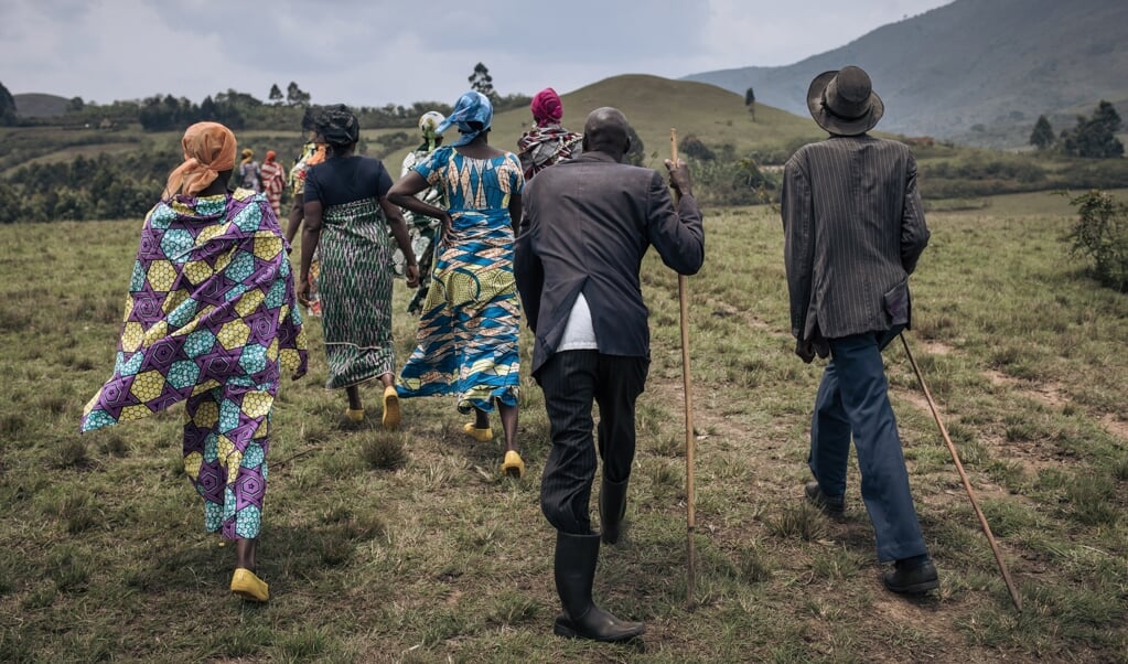 Mannen en vrouwen van de Banyamulenge zijn op weg naar de begrafenis van een herder die werd vermoord door militanten in de buurt van Minembwe in Zuid-Kivu. (beeld afp / Alexis Huguet)