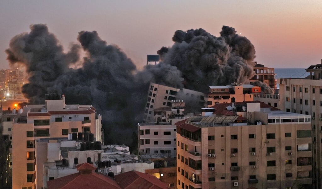 Grote roetwolken stegen dinsdag op uit de Gazastrook na een bombardement door het Israëlische leger. (beeld afp / Mohammed Abed)