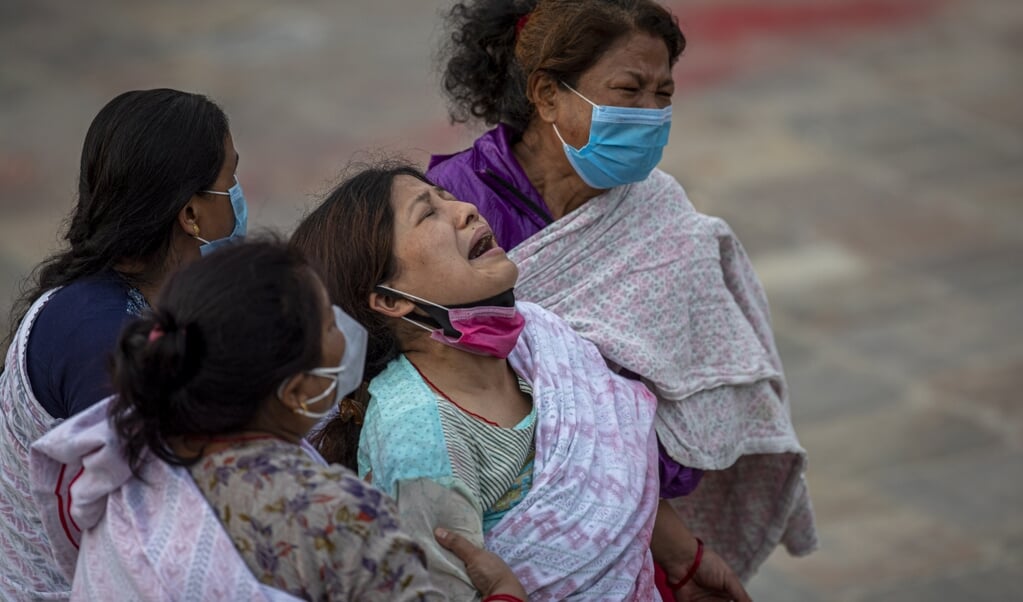 Familieleden van een Nepalees coronaslachtoffer rouwen bij een crematorium in Kathmandu. (beeld epa / Narendra Shrestha)