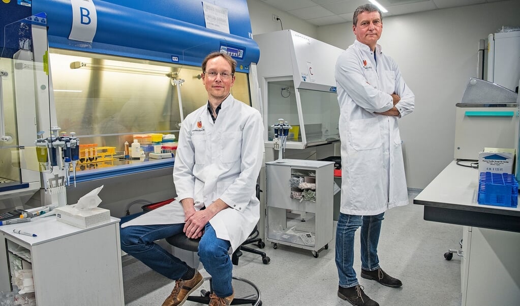 Wetenschappers Jeroen den Dunnen (links) en Menno de Winther in het laboratorium van het Amsterdam UMC. Door hun onderzoek kunnen heftige reacties op het coronavirus mogelijk worden afgezwakt. (beeld Guus Dubbelman)