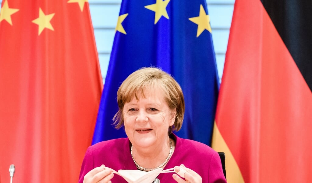2021-04-28 10:59:43 epa09164908 German Chancellor Angela Merkel takes off her face mask during the beginning of a virtual plenary session of the 6th German-Chinese government consultations in Berlin, Germany, 28 April 2021. Chinese and German ministers meet for the 6th time on 28 April 2021. Due to the ongoing Coronavirus crisis, virtually this time. EPA/CLEMENS BILAN / POOL (beeld Epa/clemens Bilan / Pool)