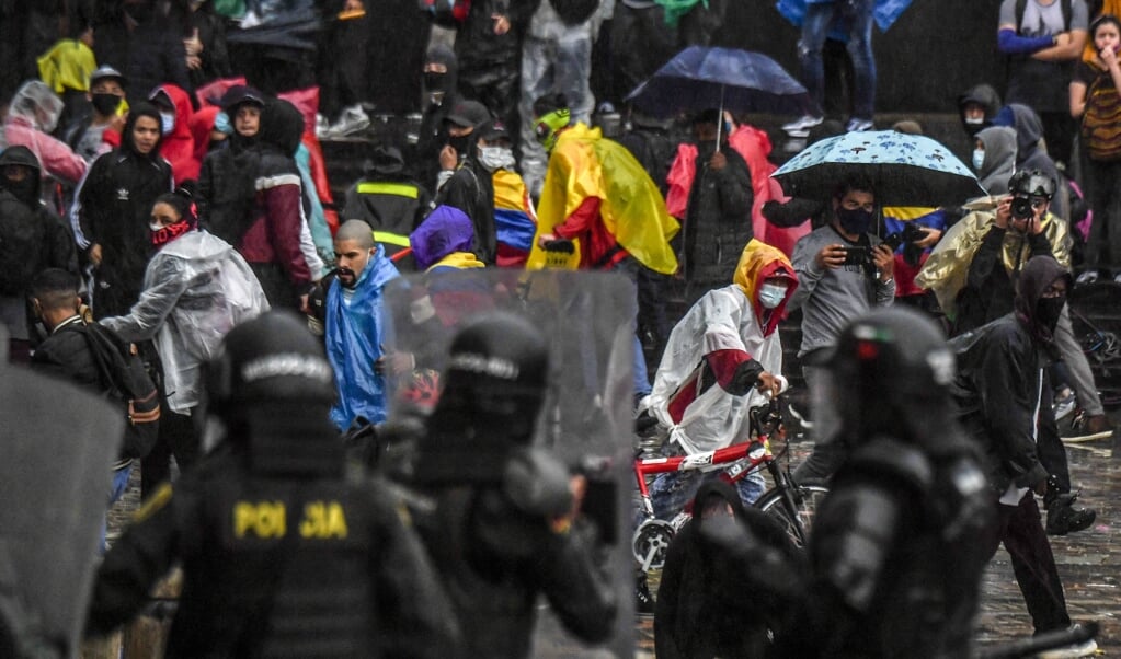 Colombiaanse demonstranten komen in aanvaring met de oproerpolitie tijdens een grootschalig protest in de hoofdstad Bogotá. (afp / Juan Barreto)