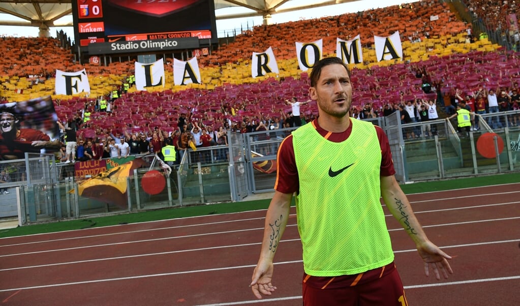 'Totti is Rome', leest het spandoek achter Francesco Totti. In mei 2017 nam hij afscheid van de fans. (beeld Vincenzo Pinto / afp)