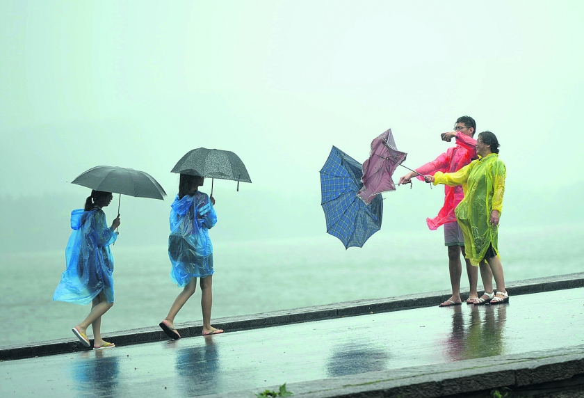 beeld ap / chinatopix
Toeristen in het Chinese Hangzhou kunnen nog wel lachen om hun omgewaaide paraplu’s. Maar zo’n 1,1 miljoen men.. (ap / chinatopix)