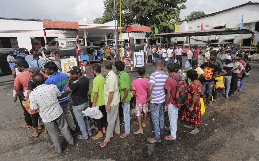 Voor tankstations in Sri Lanka staan lange rijen mensen om brandstof te kopen, zoals hier in de stad Colombo. In het Zuid-Aziatische land is sinds vrijdag sprake van een groot olietekort (ap / Eranga Jayawardena)