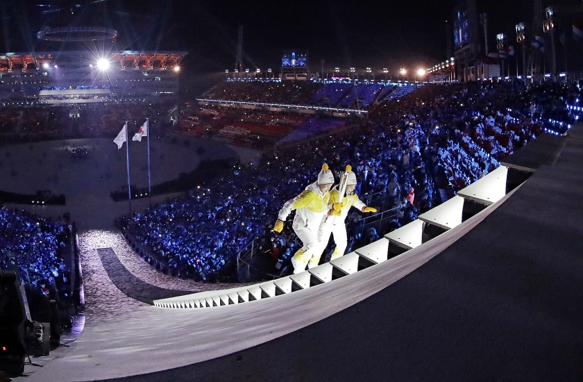 Jong Su Hyon uit Noord-Korea (l. ) en Park Jong-ah uit Zuid-Korea dragen samen de olympische vlam tijdens de openingsceremonie van de Olympische Winterspelen in Pyeongchang (Zuid-Korea) (ap / David J. Phillip)