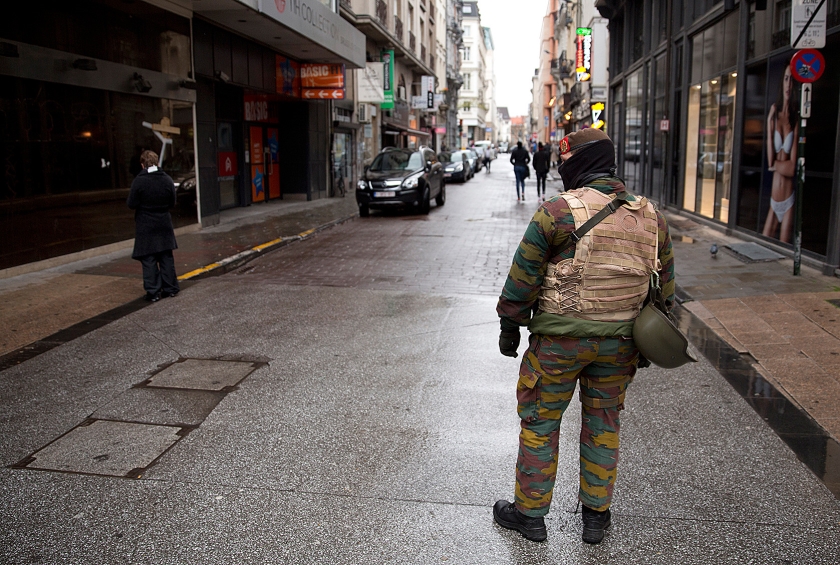 Een Belgische militair patrouilleert door een vrijwel verlaten winkelstraat in Brussel. De Belgische regering verhoogde zaterdag het terreuralarm naar het hoogste dreigingsniveau, omdat gevreesd werd voor aanslagen in Brussel, vergelijkbaar met die in Parijs een week geleden (ap / Thierry Monasse)