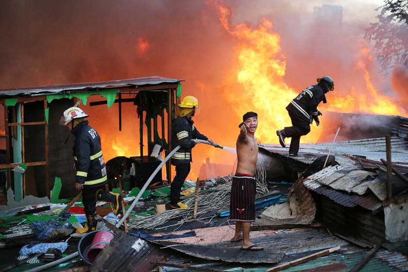 Door een grote brand in een woonwijk in de Filipijnse stad Mandaluyong, ten oosten van de hoofdstad Manilla, zijn woensdag zo’n tweehonderd huizen verwoest. Ongeveer duizend gezinnen zijn door de brand ineens dakloos geworden (ap / Aaron Favila)