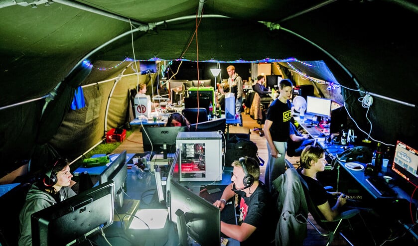 Gamers in een tent op de camping van CampZone, waar ze tegen elkaar kunnen gamen. Uit onderzoek blijkt dat matig gamen positieve effecten heeft op het welbevinden. Toch erkent de WHO gameverslaving als een officiële verslaving. (anp / Remko de Waal)