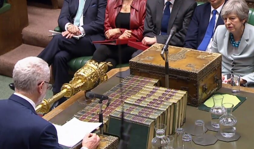 De Britse premier Theresa May luistert naar oppositieleider Jeremy Corbyn, terwijl die in het Lagerhuis spreekt over het brexitproces. (afp)