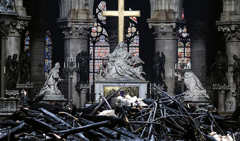 In het gouden kruis dat tussen de zwartgeblakerde brokstukken van de Notre-Dame verrijst, ziet De Hek paassymboliek. (afp / Ludovic Marin)