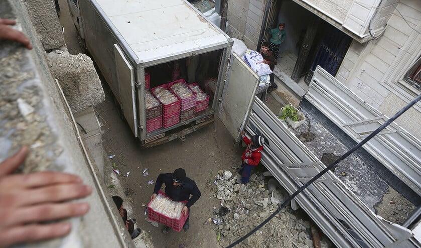Vrijwilligers helpen in Douma en Oost-Ghouta met het uitdelen van humanitaire goederen na luchtaanvallen door Syrische en Russische vliegtuigen. De belegerde stadswijken in Damascus zijn in handen van rebellenmilities. (ap / Samer Bouidani)