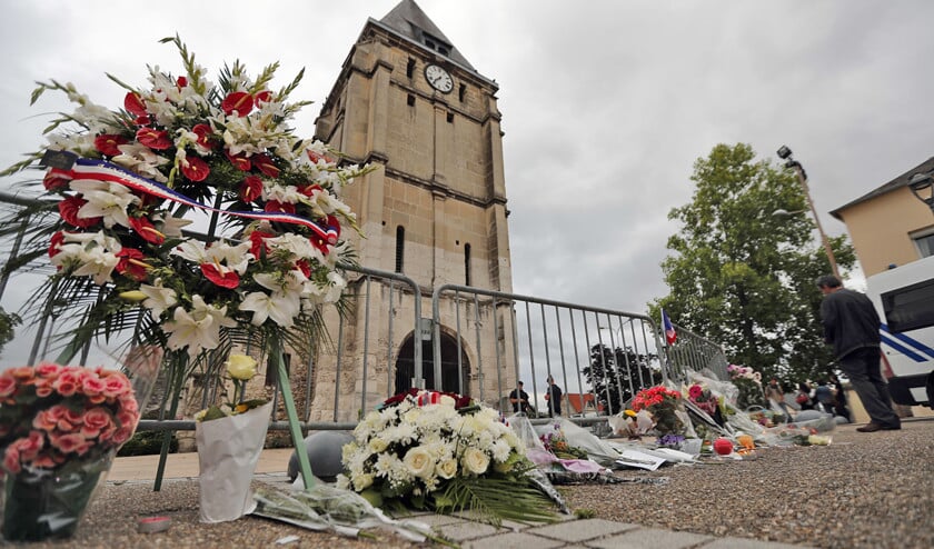 Rondom de kerk in Saint-Étienne-du-Rouvray wordt gerouwd. Kort voor Adel Kermiche met twee anderen de kerk binnenviel, zou hij nog tegen een buurtgenoot hebben gezegd dat hij ‘iets in de kerk zou gaan doen’. (ap / Francois Mori)