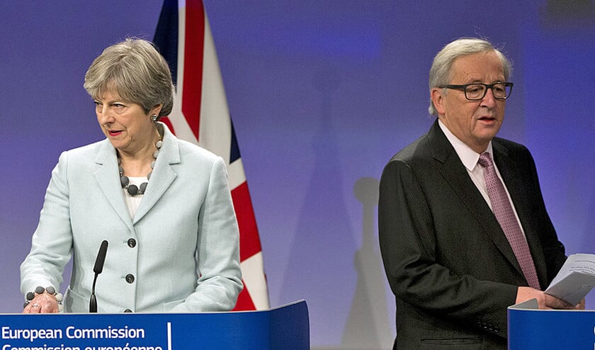 De Britse premier Theresa May en voorzitter Jean-Claude Juncker van de Europese Commissie, vrijdag bij de bekendmaking van het deelakkoord. (ap / Virginia Mayo)