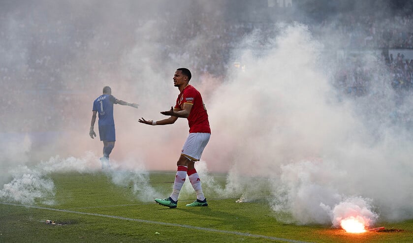AZ-speler Ricardo van Rhijn vraagt het publiek voorafgaand aan de wedstrijd te stoppen met vuurwerk. Fotograaf Olaf Kraak, die deze foto maakte, liep gehoorschade op. ‘Ik was niet veilig. Het ging alle perken te buiten.’ (anp / Olaf Kraak)