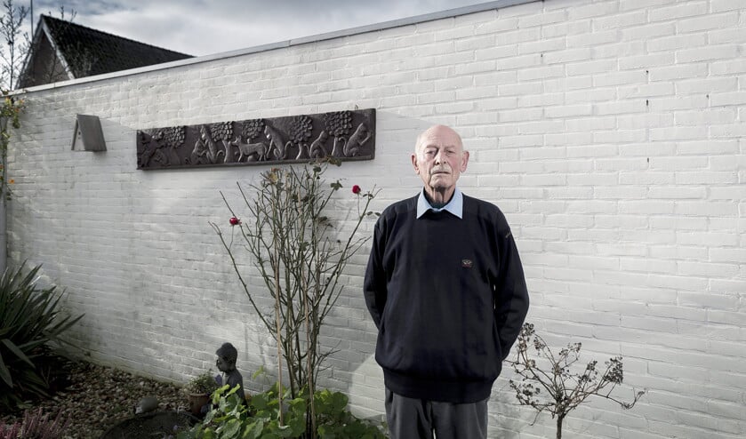Karel Wielenga in zijn tuin in Woudsend, waar een kunstwerk uit Indonesië aan de muur hangt. ‘Ik heb begrip voor de kapers, alleen niet voor de manier waarop ze het deden.’ (Sjaak Verboom en Anton Dommerholt)