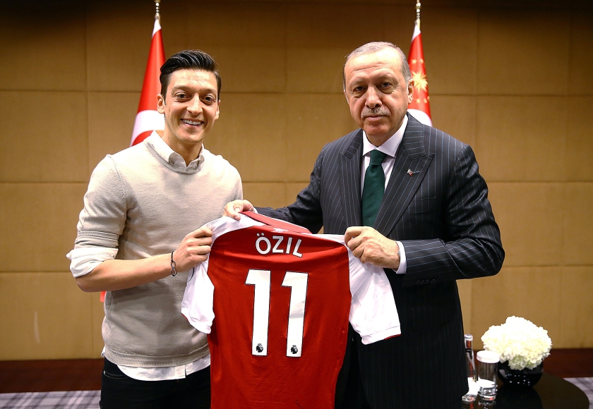 De gewraakte foto waarop de Duitse voetballer Mesut Özil, die bij de Engelse club Arsenal speelt, de Turkse president Erdogan een voetbalshirt van hemzelf aanbiedt tijdens een ontmoeting in Londen in mei dit jaar. (epa / turkish presidential press office)
