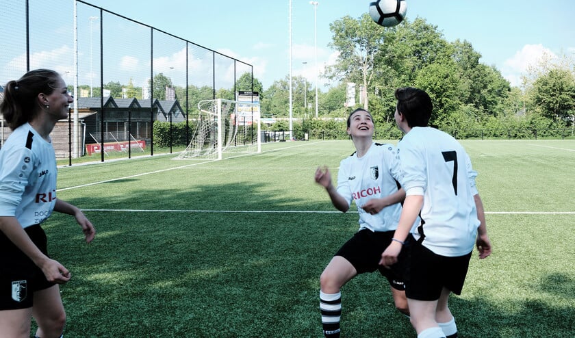 Dewi, Meral en Maryse vieren op het voetbalveld dat de examens erop zitten. ‘Ik vind dit belangrijker dan school.’ (Dick Vos)